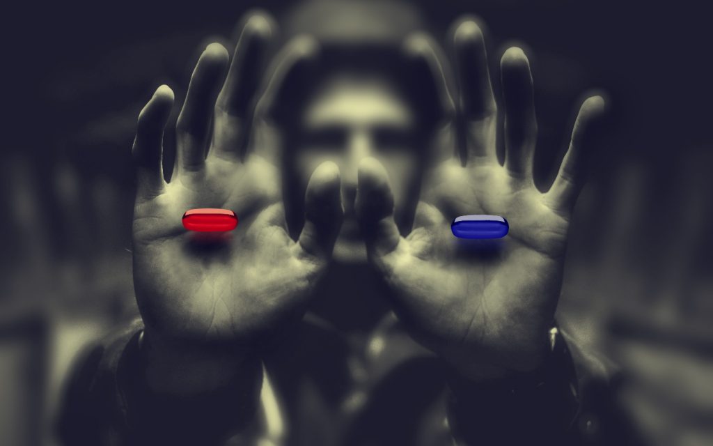 Man holding blue and red pill