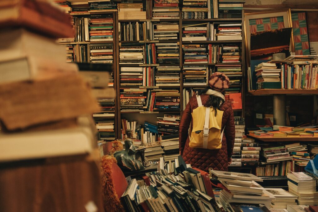 Cluttered book store with a person trying to find a book